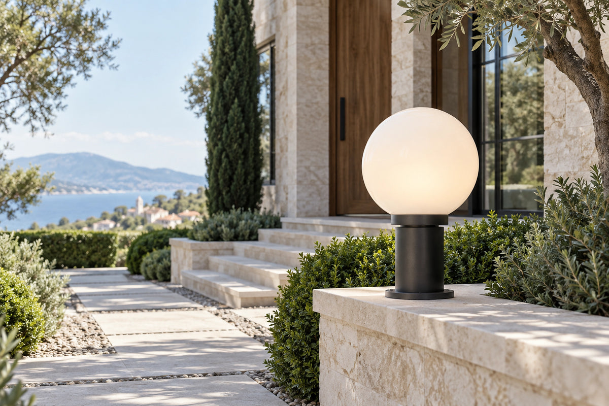 Lampe boule extérieur à globe opalin près d’un chemin en pierre claire, en plein jour
