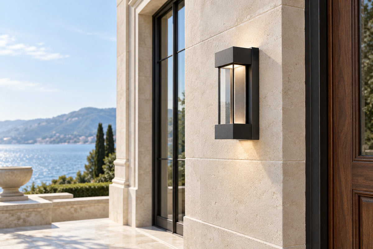 Luminaire extérieur gris anthracite sur une façade en pierre claire, sous une lumière naturelle