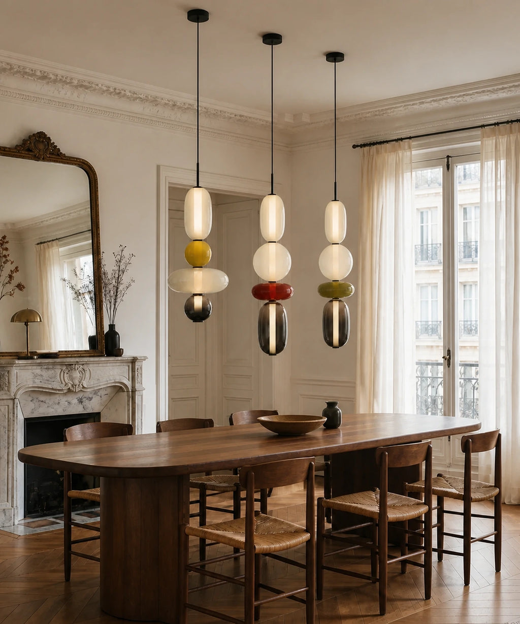 Trois suspensions en verre allumées au-dessus d’une table à manger nette