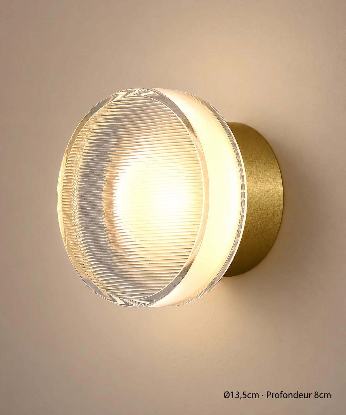 Applique dorée à fines stries, diamètre 13,5 cm et profondeur 8 cm, sur un fond brun-beige.