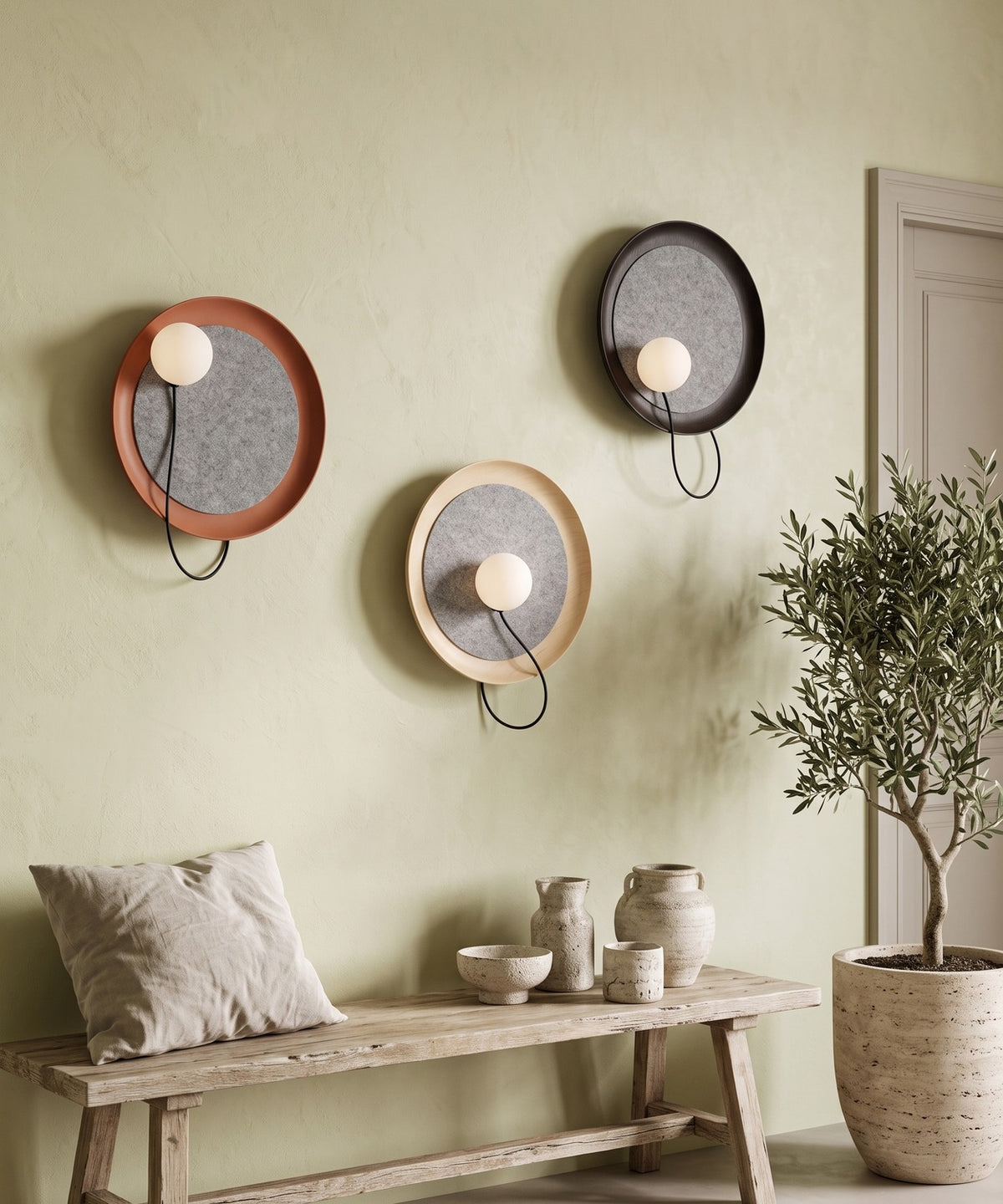 Trois appliques aux finitions noire, terracotta et crème sur le mur d'un séjour bohème