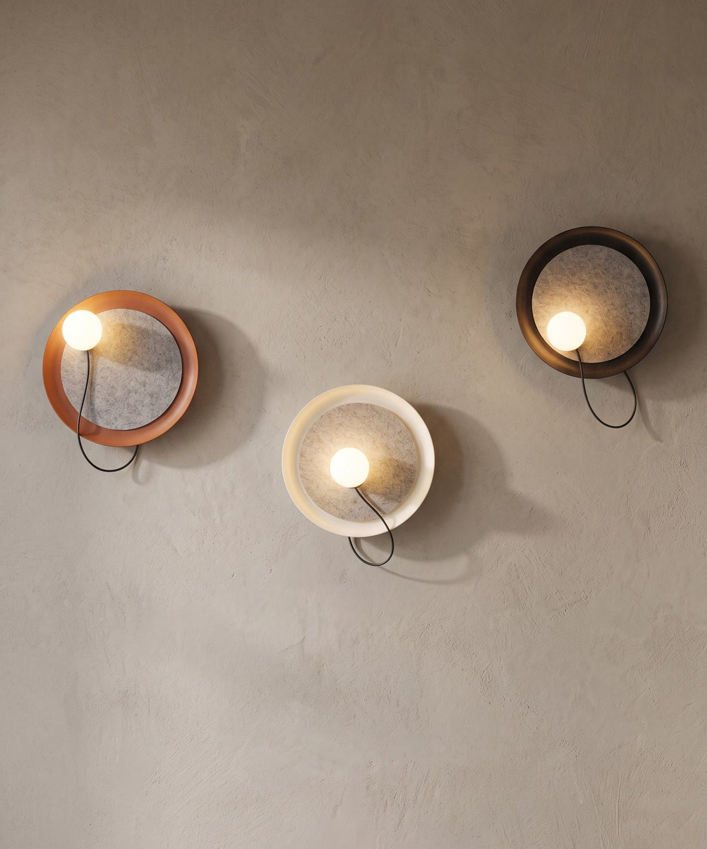 Trois appliques murales à disque en feutre, finitions noire, terracotta et crème