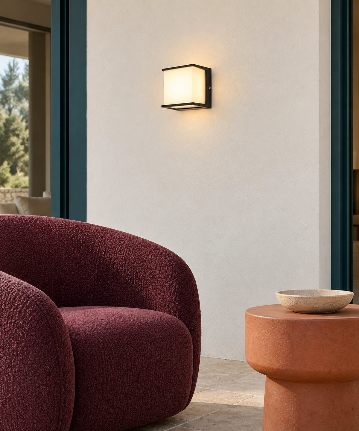 Petite applique noire à lumière diffuse au-dessus d’un fauteuil de terrasse