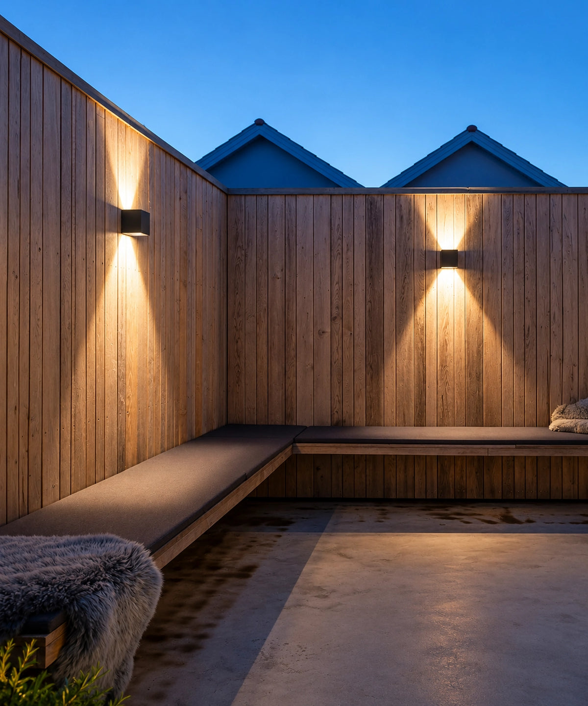 Appliques cubes noires allumées sur un bardage en bois, au-dessus d’une banquette extérieure Image