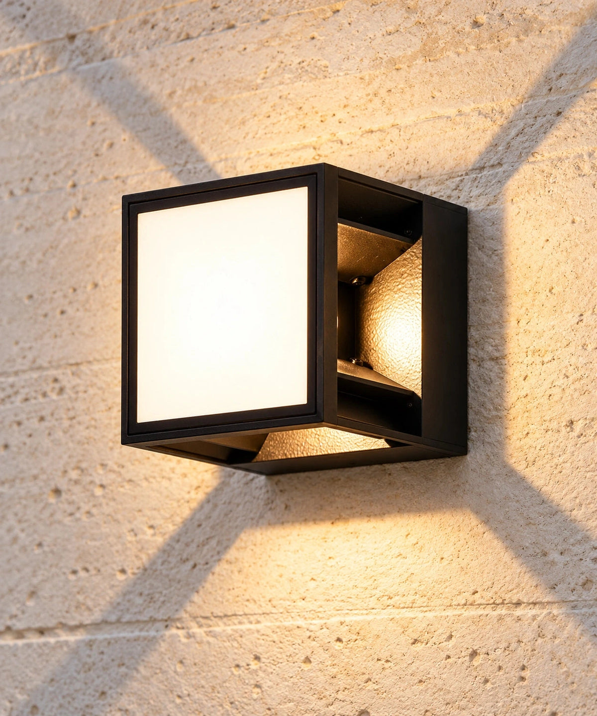 Applique extérieure noire allumée en vue proche, avec face carrée et effet lumineux en X
