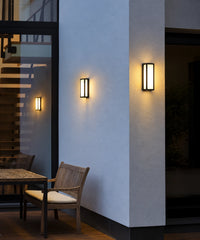 Lanternes noires allumées autour d’une terrasse, faces lumineuses et halo sur les murs