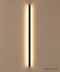 Applique longue noire de 100 cm allumée sur un mur clair, avec dimensions indiquées