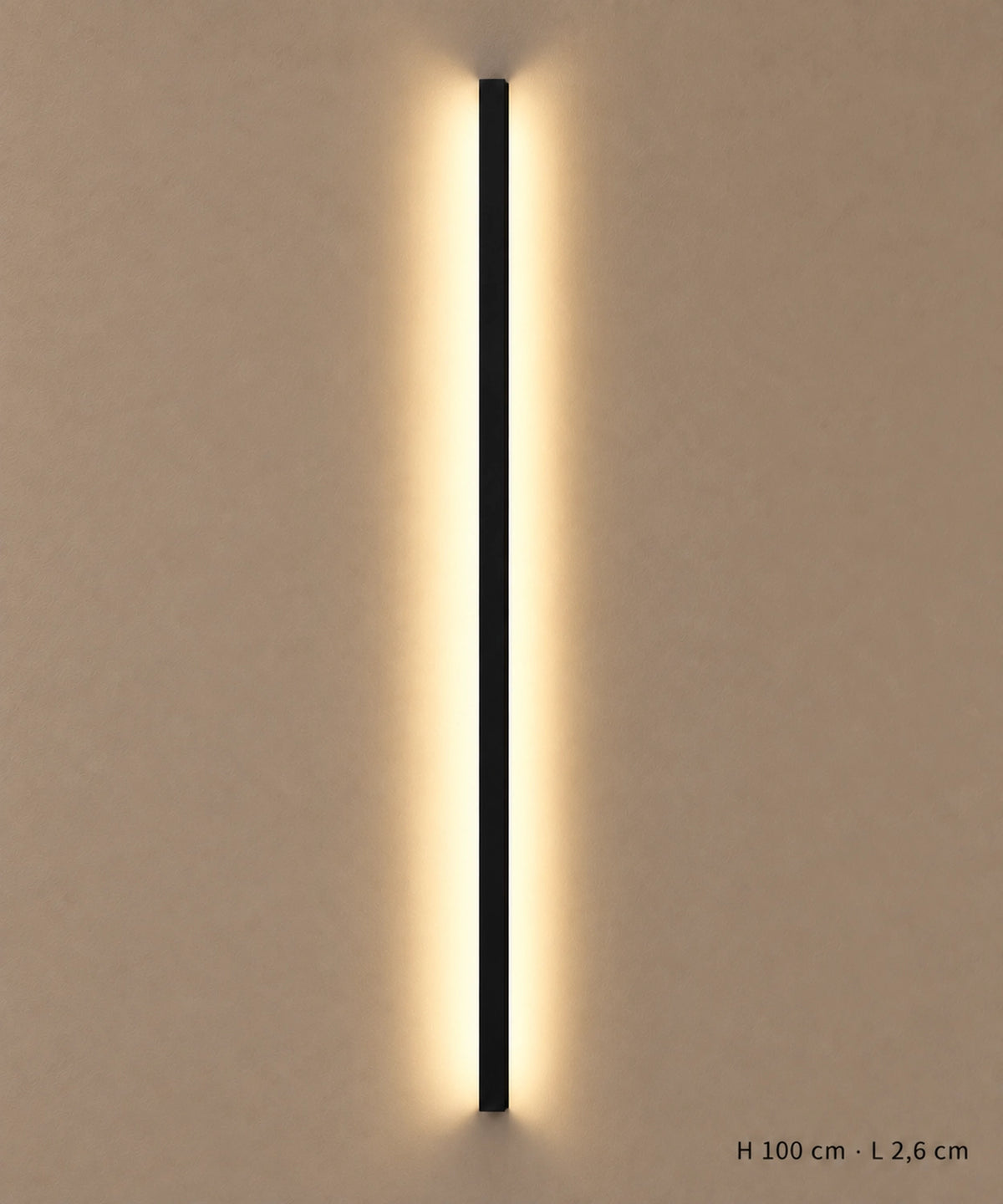 Applique longue noire de 100 cm allumée sur un mur clair, avec dimensions indiquées