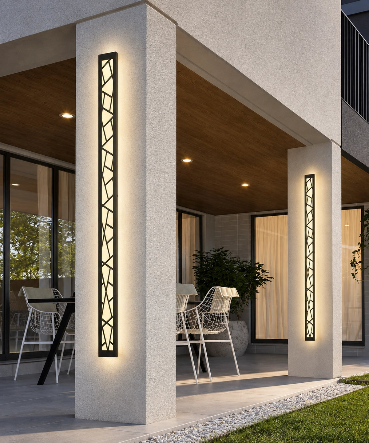 Deux appliques à motif géométrique éclairent les piliers d’une terrasse couverte