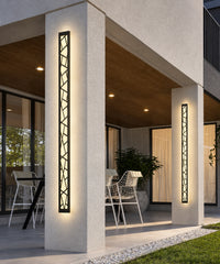 Deux appliques à motif géométrique éclairent les piliers d’une terrasse couverte