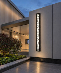 Longue applique graphique noire allumée sur le mur d’une terrasse contemporaine