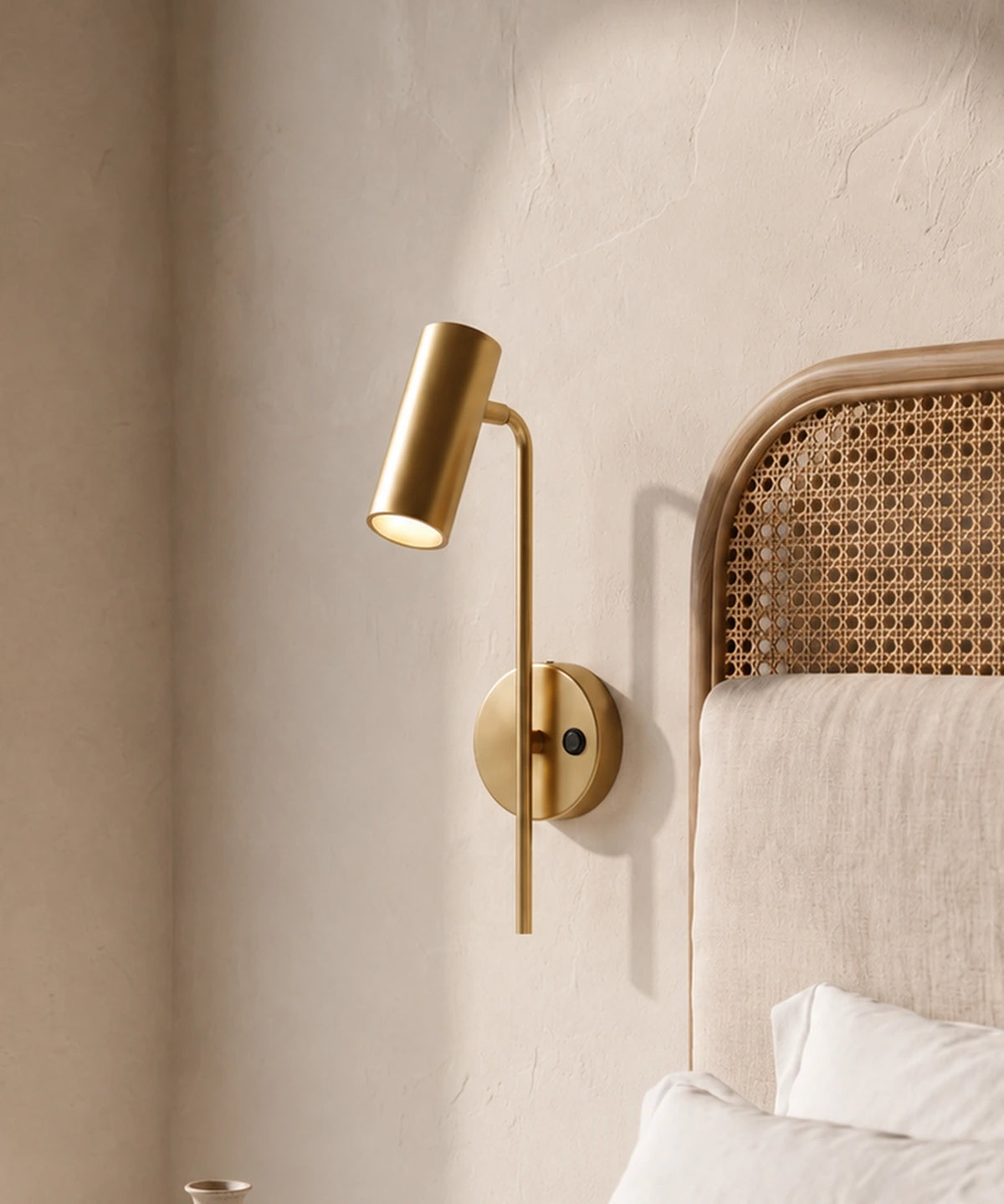 Applique liseuse orientable sur rotule en laiton, à la tête d’un lit
