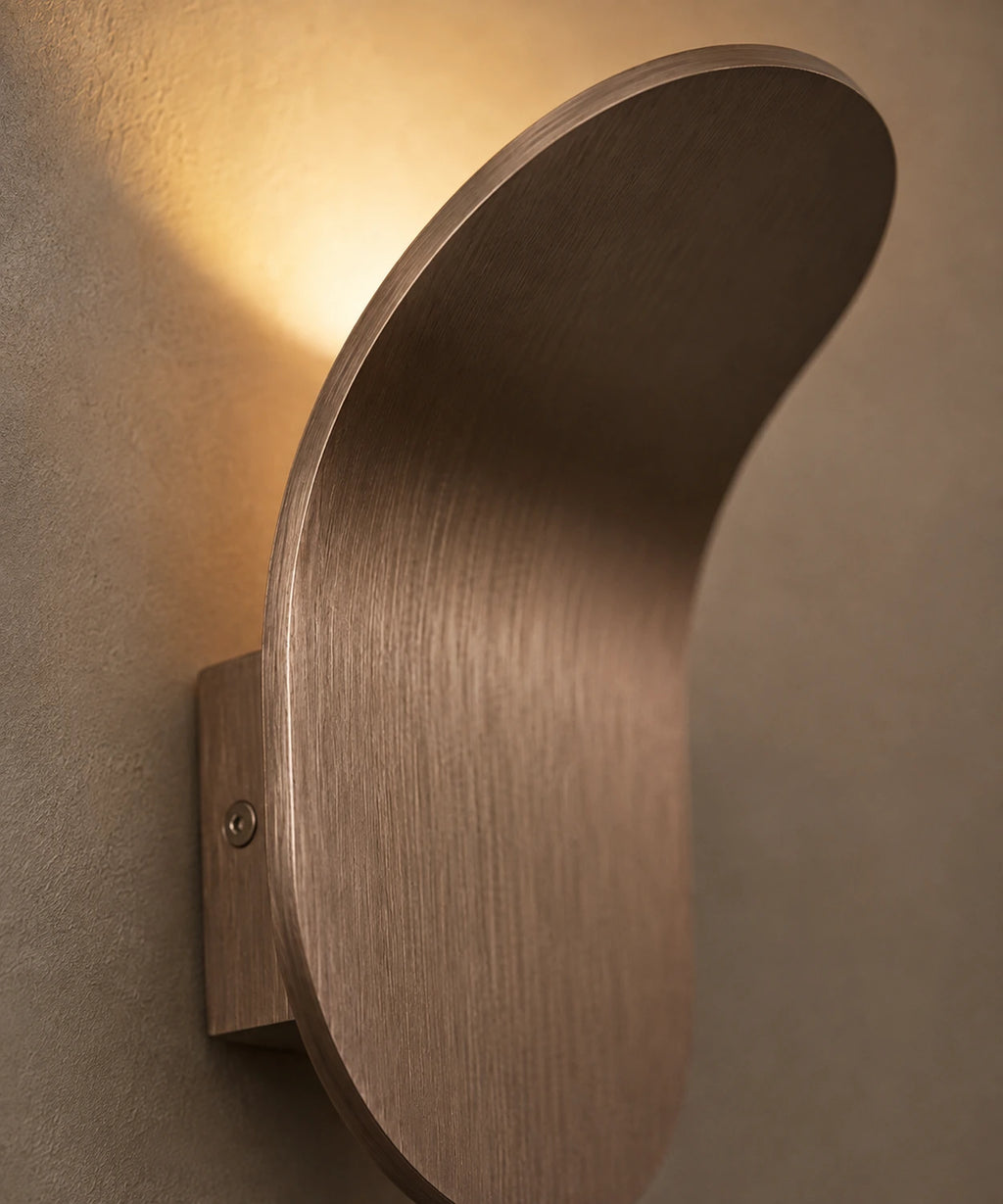 Gros plan sur la courbe de la feuille d’aluminium brossé bronze et sa vis de fixation