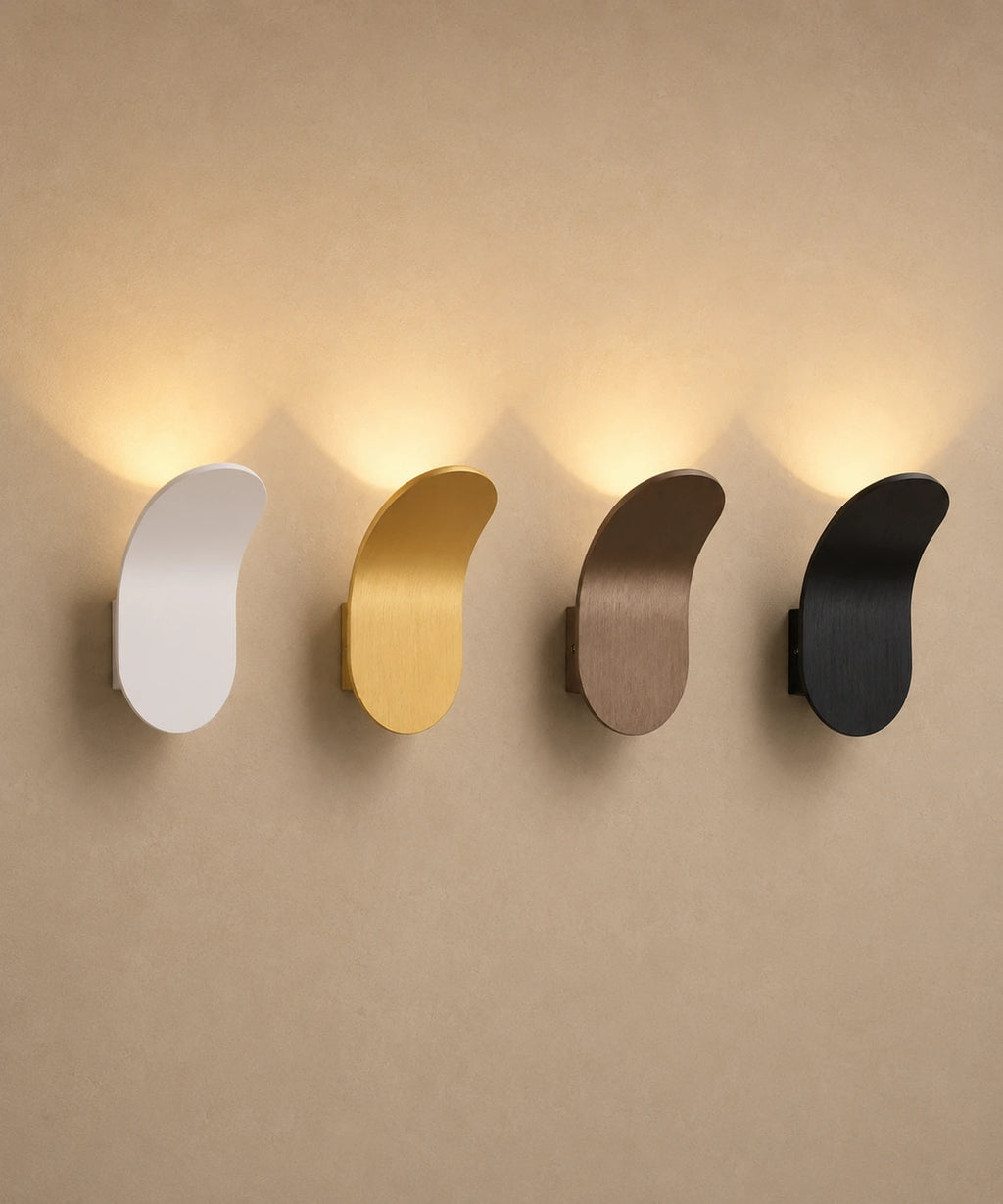 Les quatre finitions de l’applique feuille en aluminium brossé alignées sur un même mur