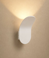 Applique murale feuille en aluminium blanc, éclairage vers le haut sur fond beige