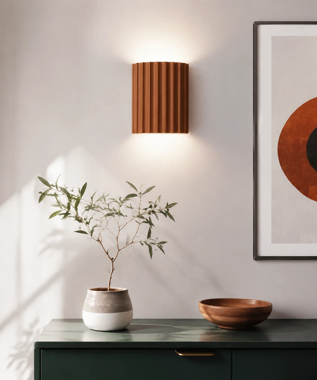 Applique murale cannelée orange allumée au-dessus d’un meuble vert