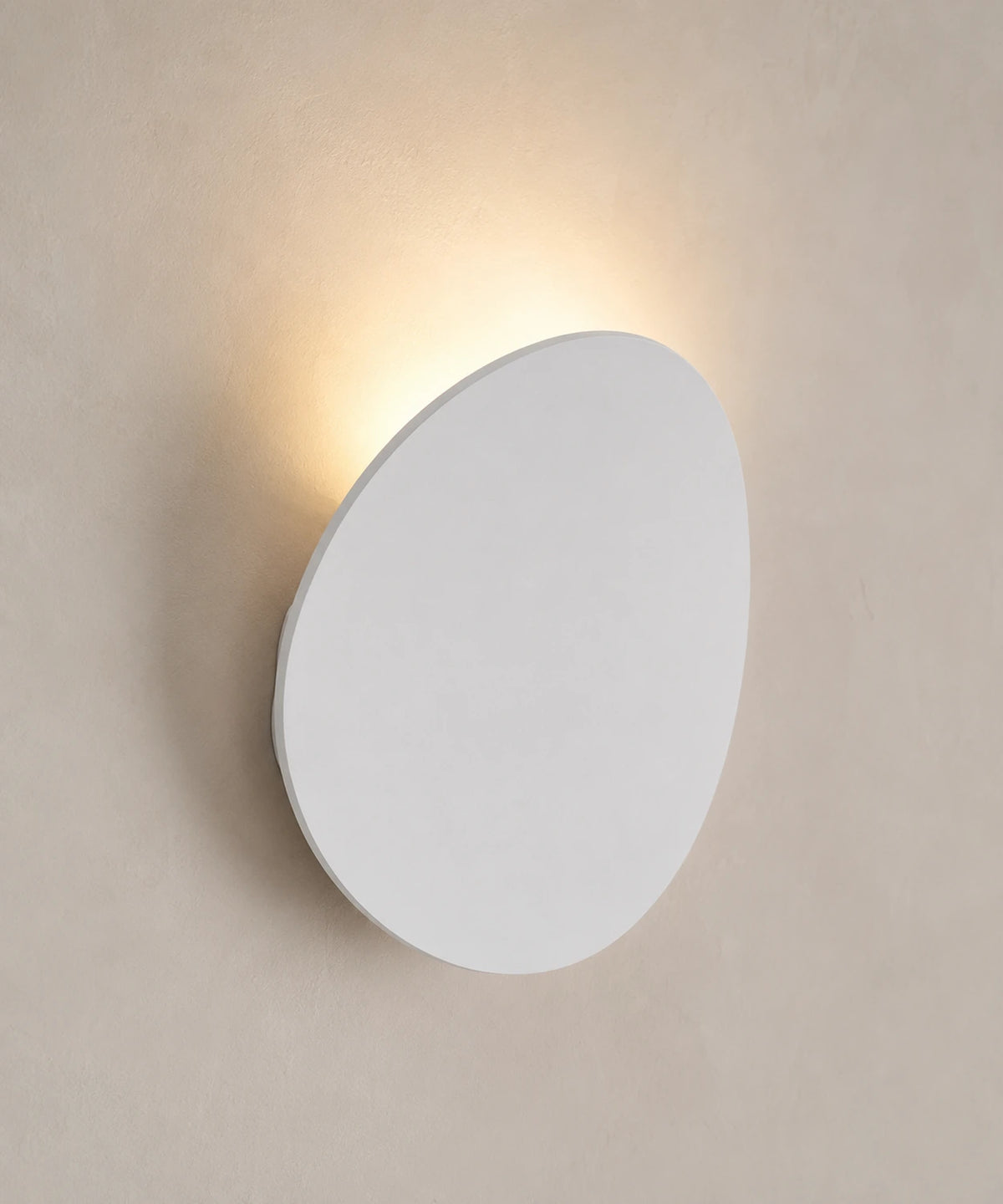 Applique murale galet en finition blanc sable, lumière renvoyée par le mur