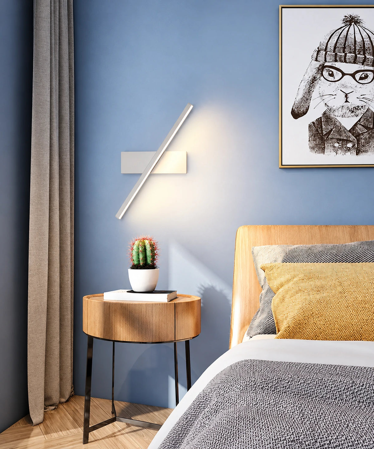 Applique LED orientable blanche sur mur bleu, au-dessus d’un chevet rond en bois