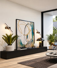 Deux appliques LED orientables noires encadrent un tableau au-dessus d’un meuble de salon