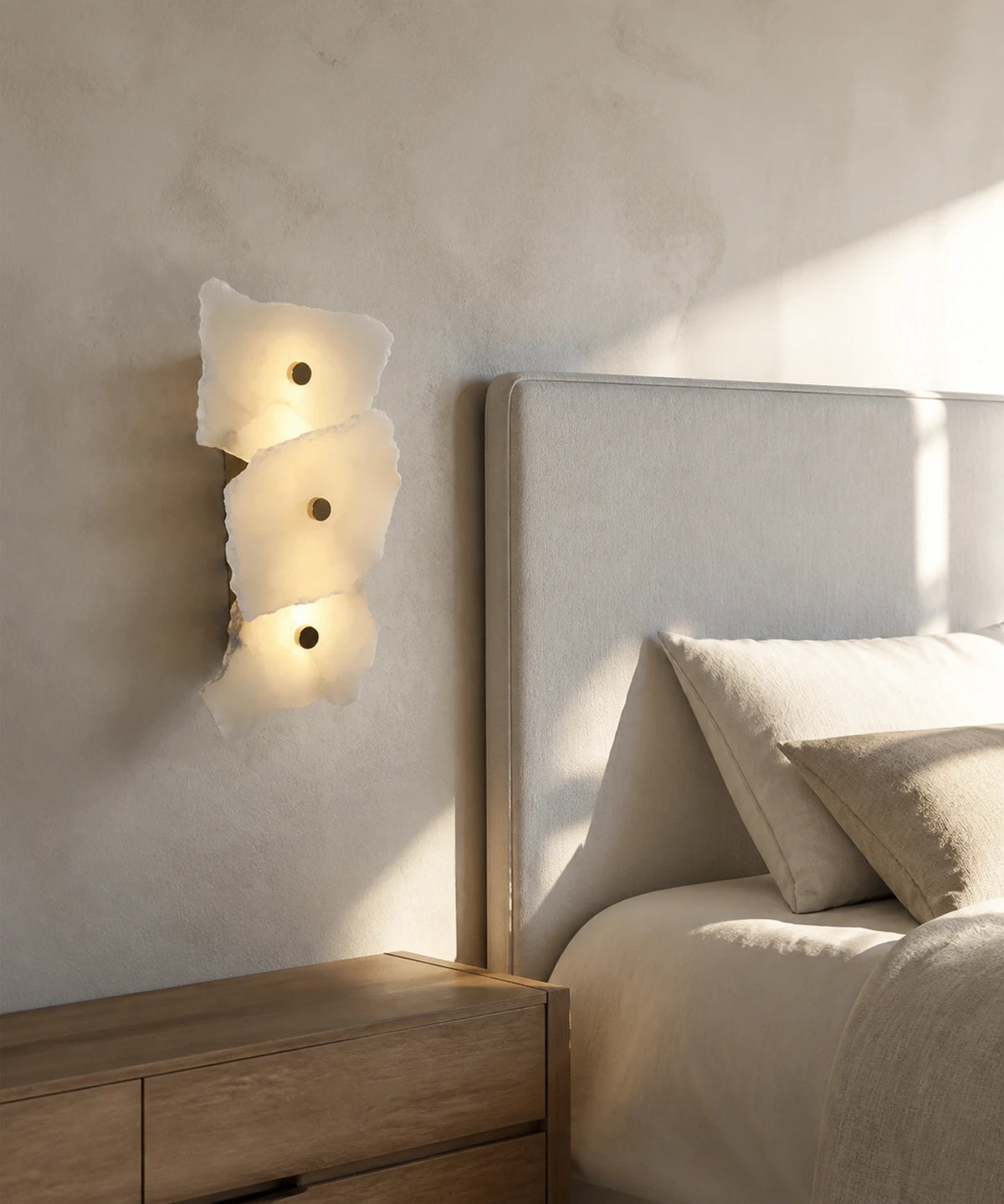 Applique murale en marbre blanc à trois plaques éclairant une tête de lit en tissu clair