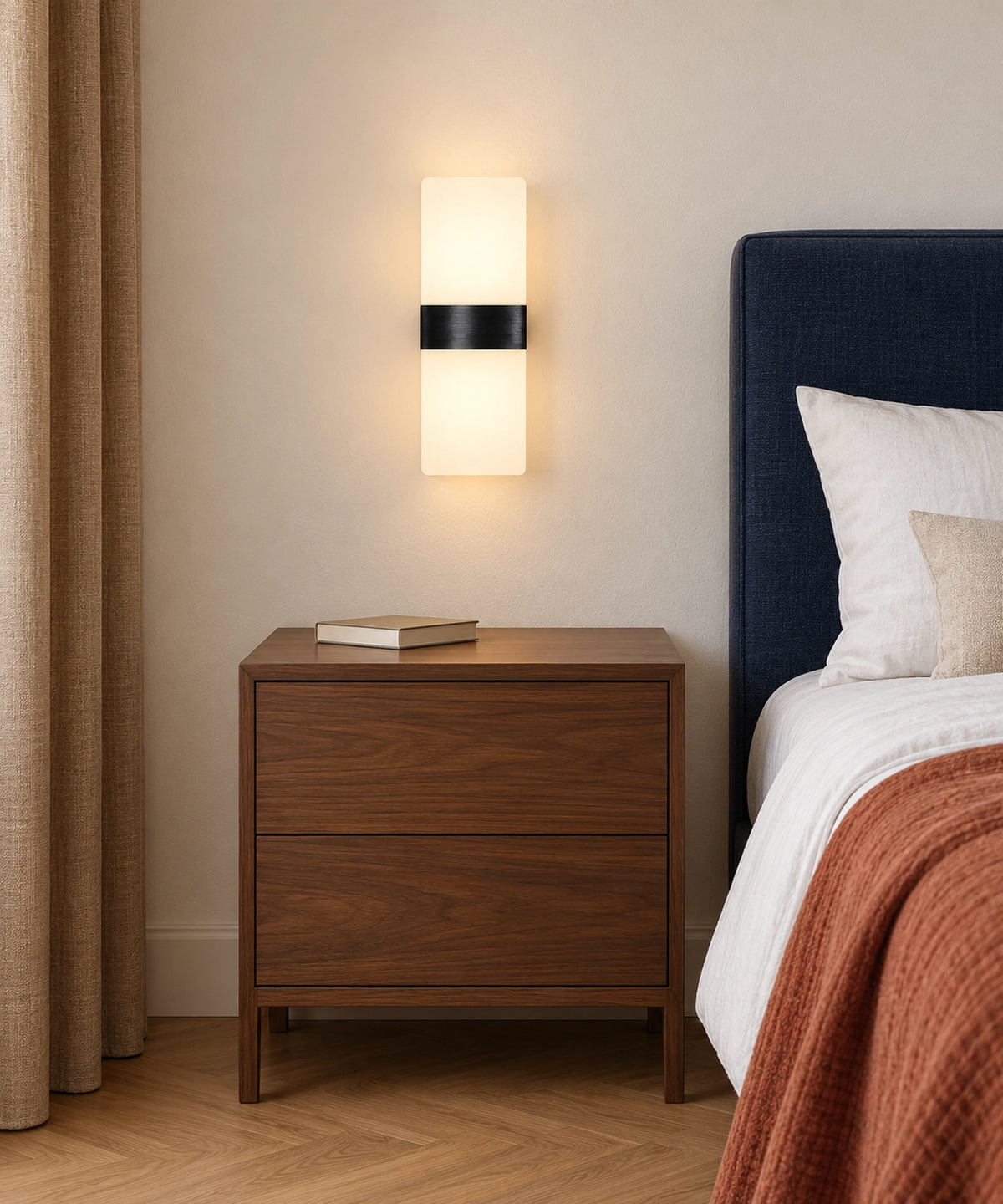 Applique noire au mur près d’un lit et d’un meuble en bois