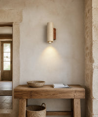 Applique murale en pierre naturelle, au-dessus d'une console en bois brut, dans une entrée