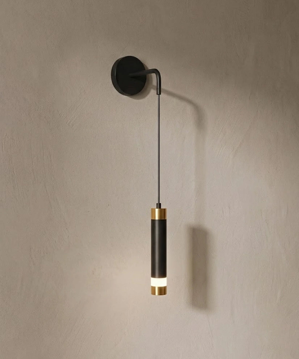 Applique murale tube suspendu, tube noir à bagues dorées sur mur en enduit