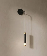Applique murale tube suspendu, tube noir à bagues dorées sur mur en enduit
