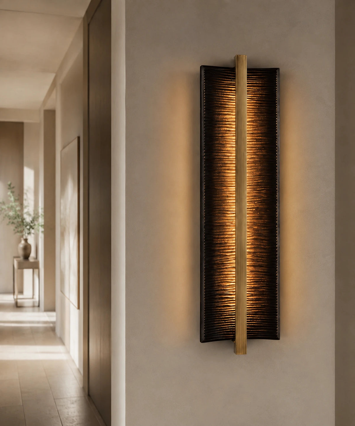 Applique murale verticale design en bronze nervuré allumée dans un couloir clair