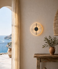 Applique ronde en albâtre allumée dans une entrée ouverte sur la mer