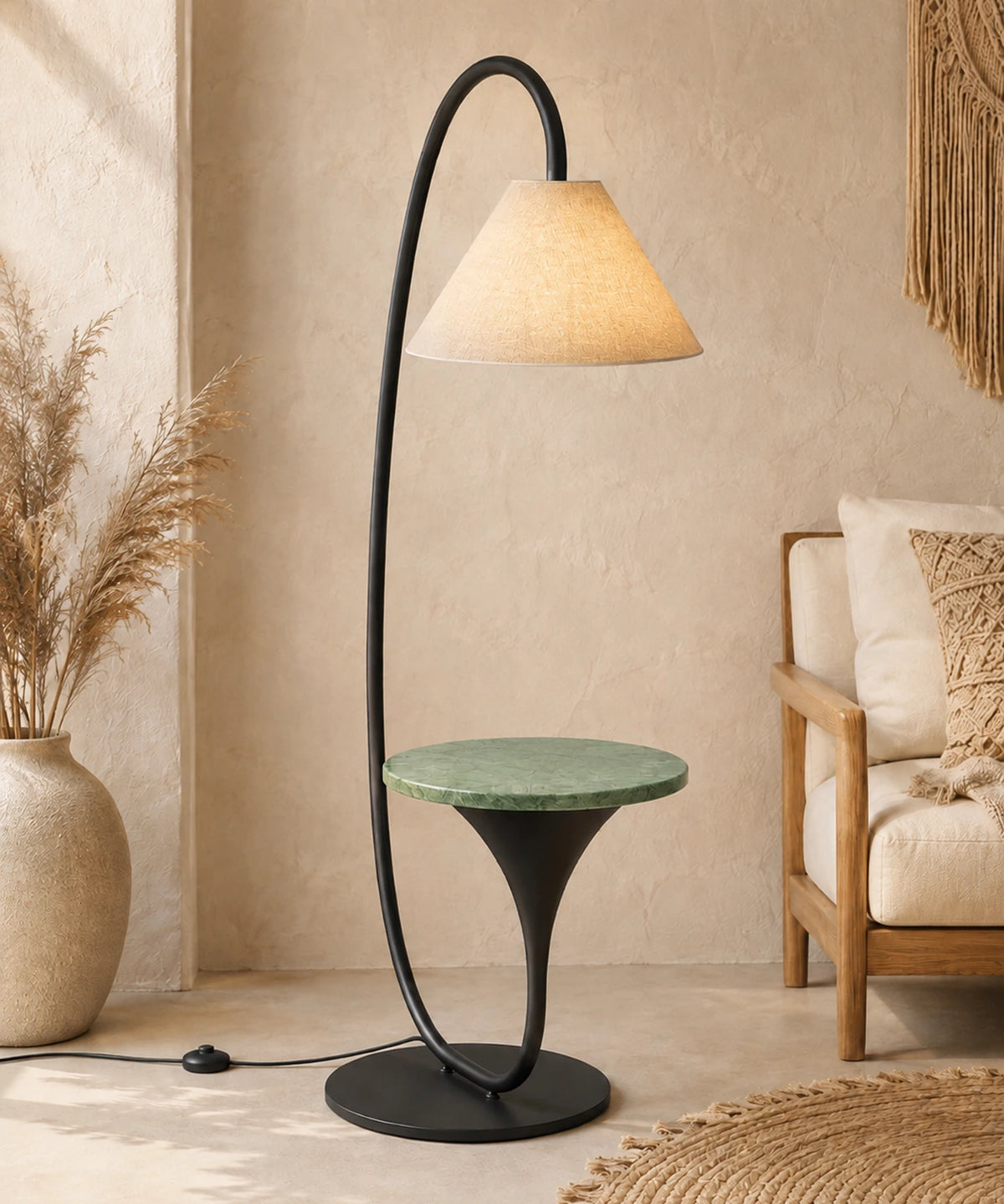 Lampadaire arc avec tablette en marbre vert allumé près d’un fauteuil en bois
