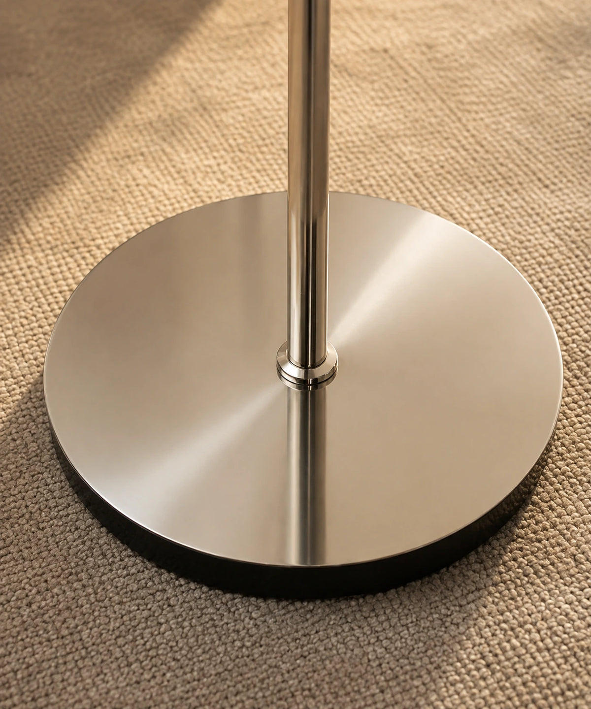 Socle rond en métal chromé poli du lampadaire champignon, posé sur un tapis