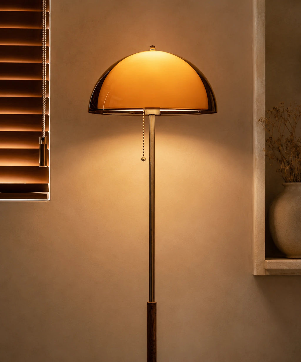 Lampadaire champignon vintage à tige chromée allumé à côté d’une bibliothèque