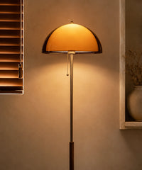 Lampadaire champignon vintage à tige chromée allumé à côté d’une bibliothèque