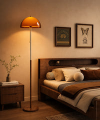 Lampadaire champignon vintage à dôme ambré allumé au chevet d’un lit en bois