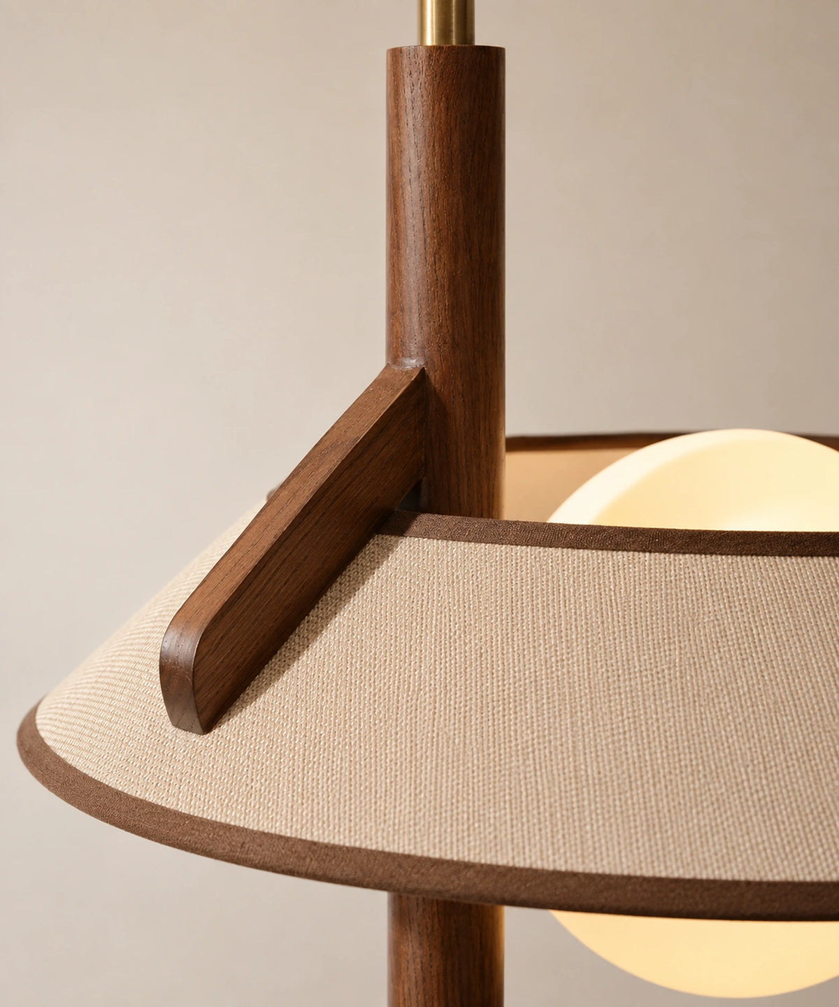 Jonction en bois massif entre le mât et l’abat-jour du lampadaire liseuse avec tablette