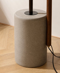 Socle cylindrique en ciment coulé du lampadaire liseuse, câble noir et mât en bois