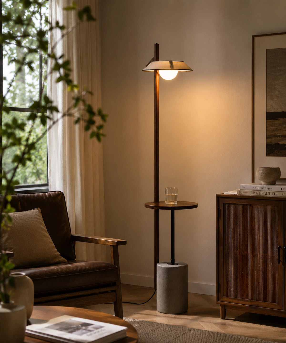 Lampadaire liseuse en bois et ciment allumé près d’un fauteuil de lecture et d’une fenêtre