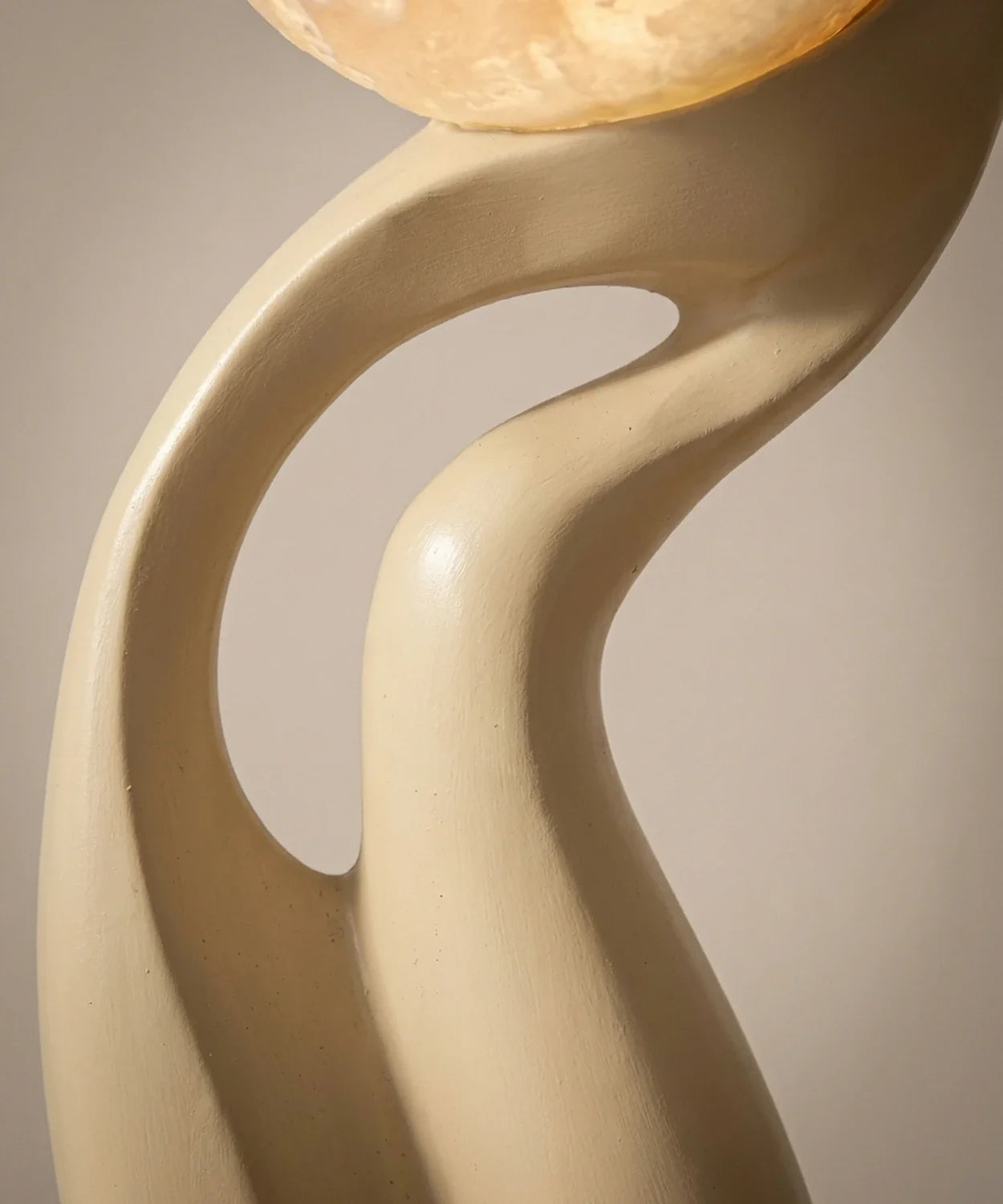 Gros plan sur les courbes enlacées et la finition peinte à la main du lampadaire sculpture