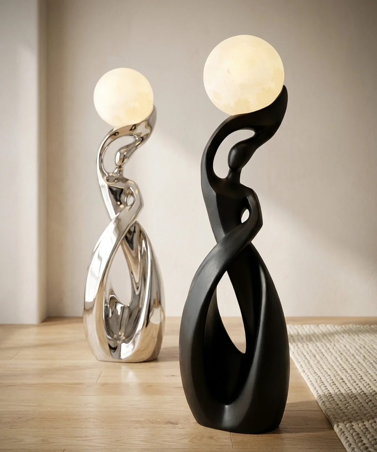 Deux lampadaires sculpture, finitions noir mat et chrome, posés dans un salon clair
