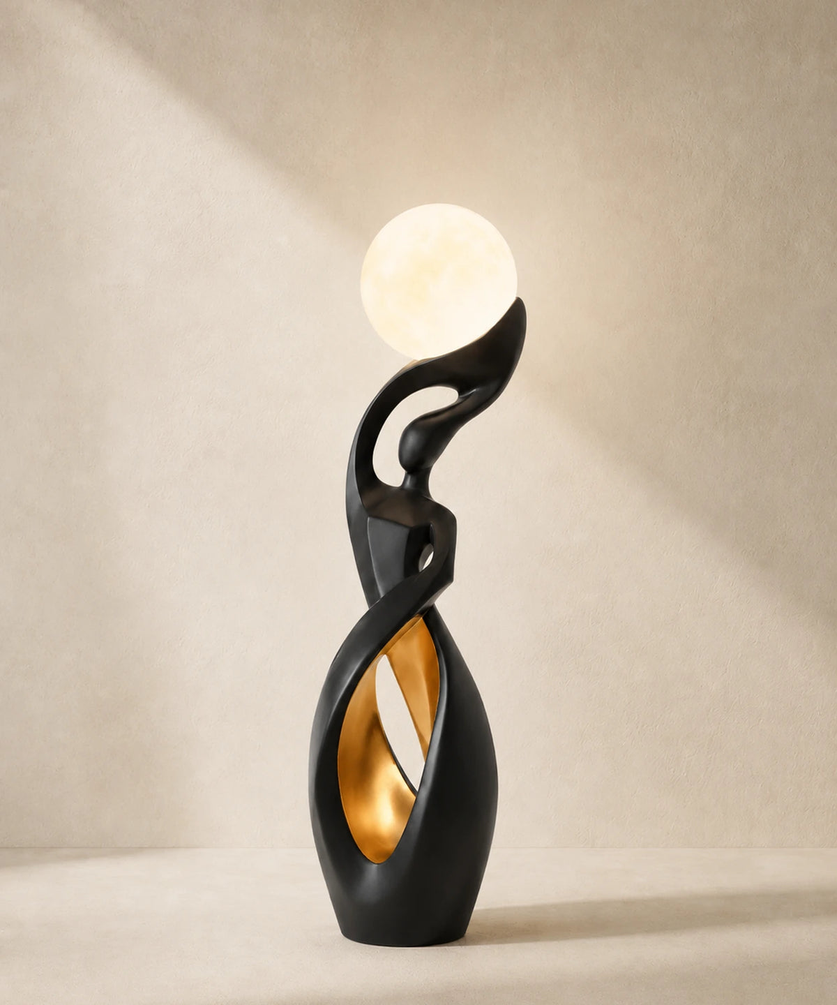 Lampadaire sculpture noir mat et doré, lune allumée, feuille d’or dans le creux de la boucle