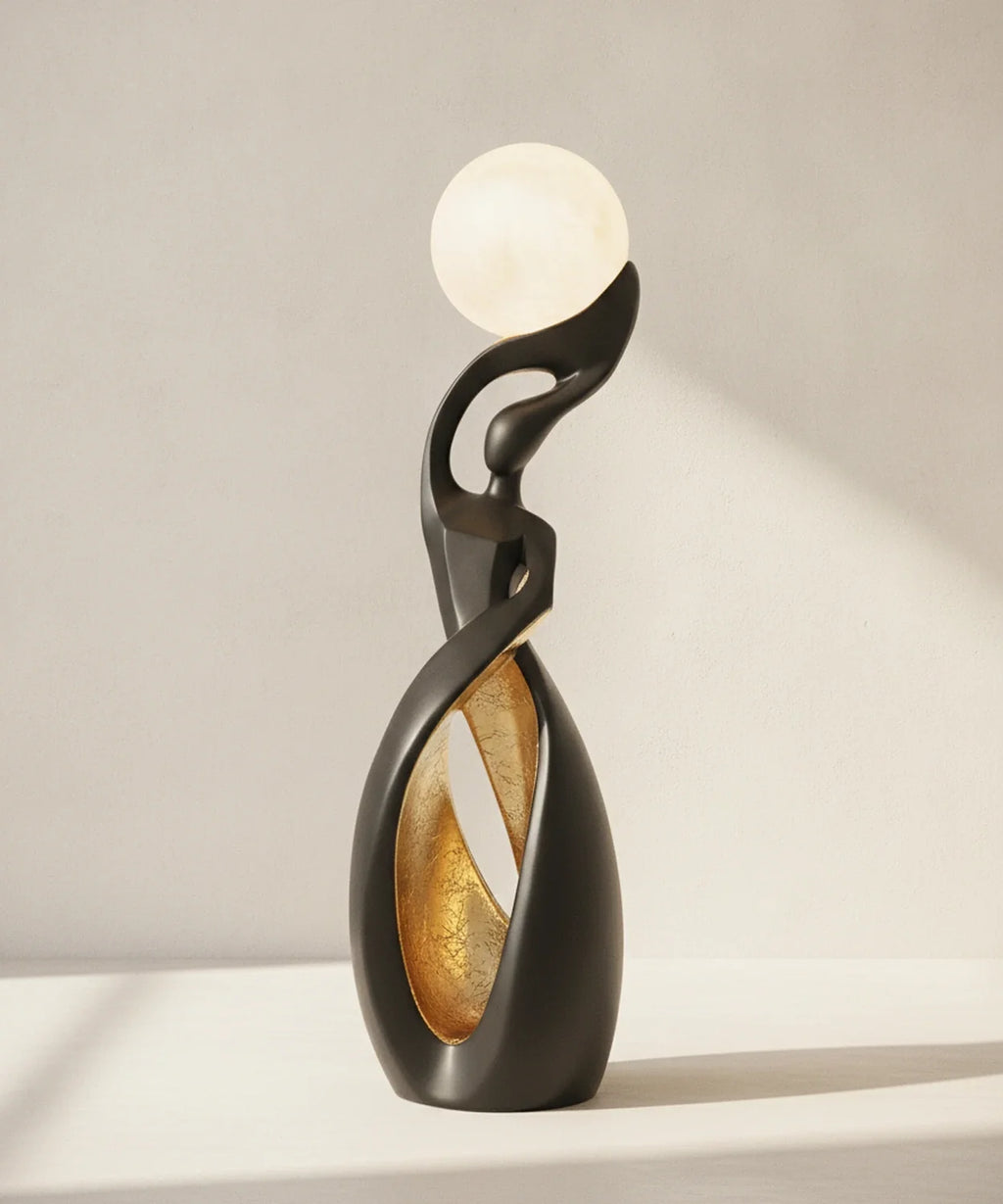 Lampadaire sculpture noir mat avec feuille dorée dans le creux de la boucle