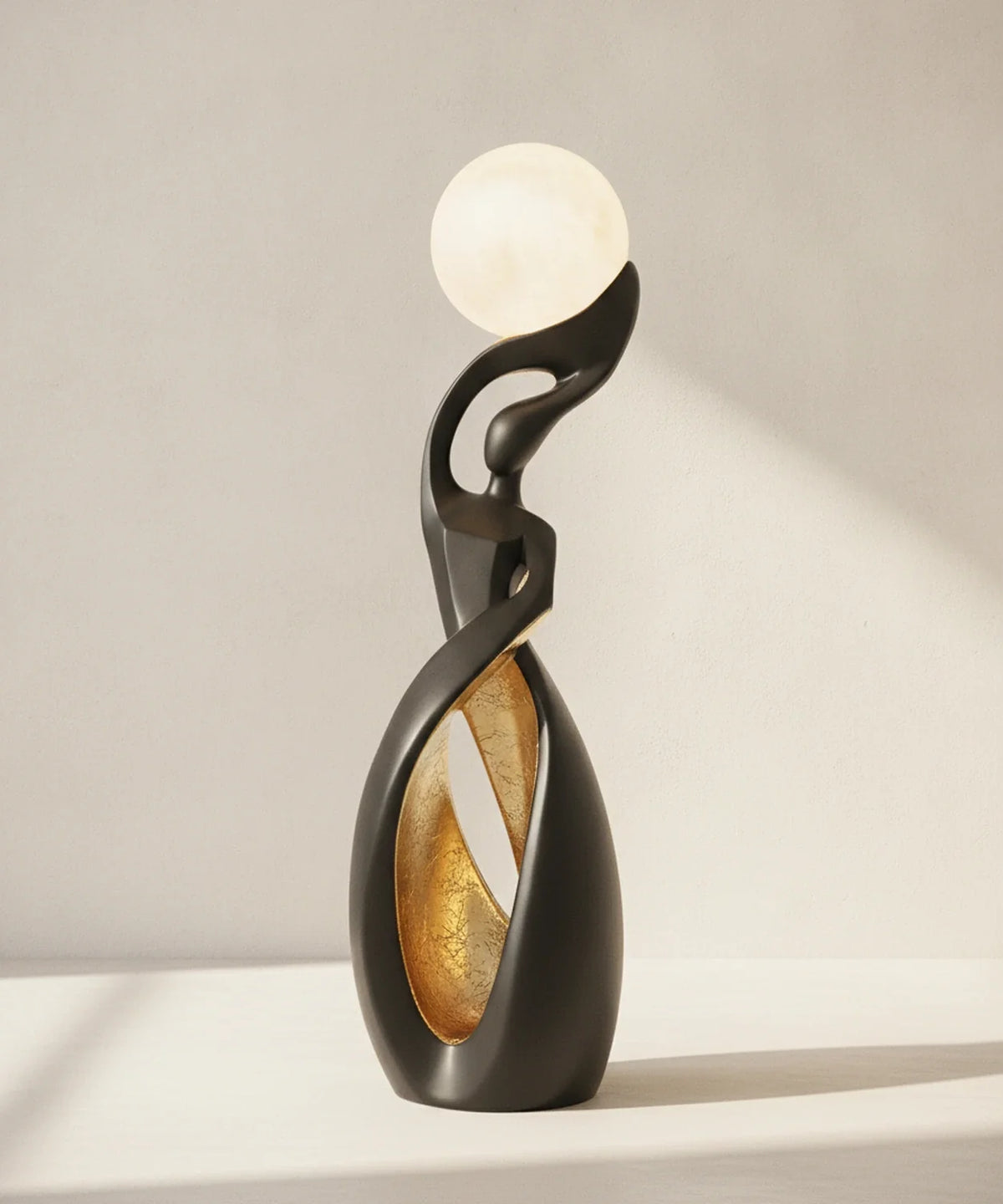 Lampadaire sculpture noir mat avec feuille dorée dans le creux de la boucle