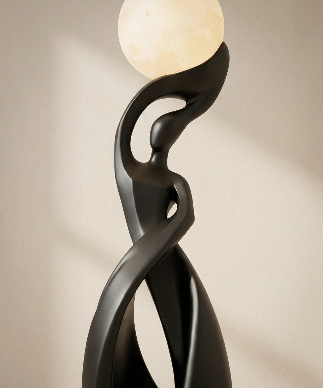 Sphère lune allumée portée par les deux figures enlacées du lampadaire sculpture Image