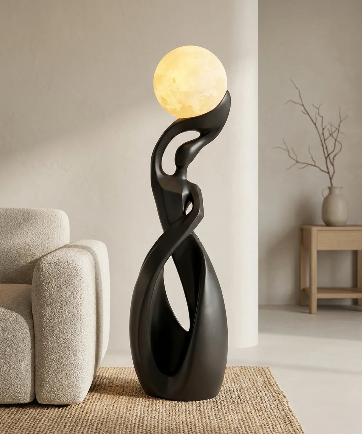 Lampadaire sculpture noir mat allumé près d un canapé en bouclé et d un tapis en jute