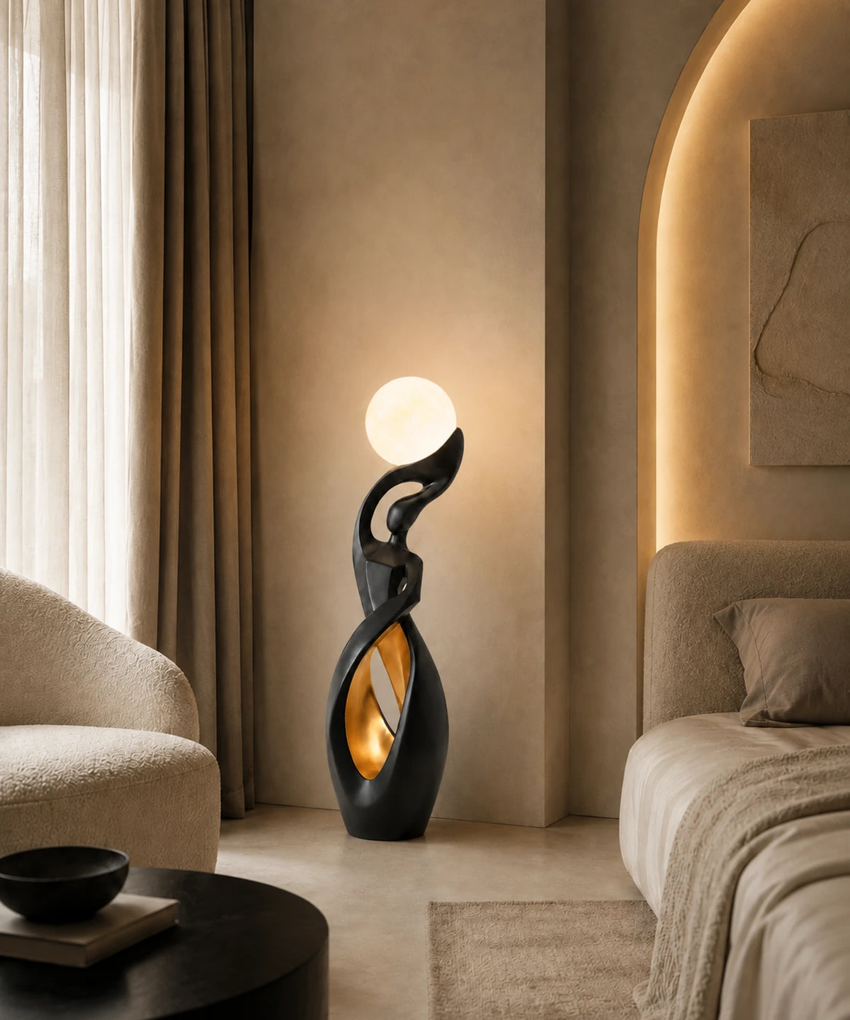 Lampadaire sculpture noir et doré allumé au pied d’un lit, feuille dorée dans la boucle
