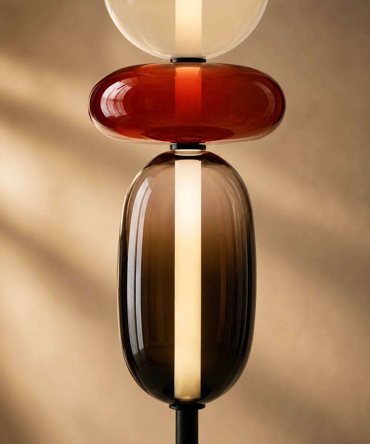 Gros plan sur la boule rouge et le globe fumé de la lampe à poser, tube LED au centre