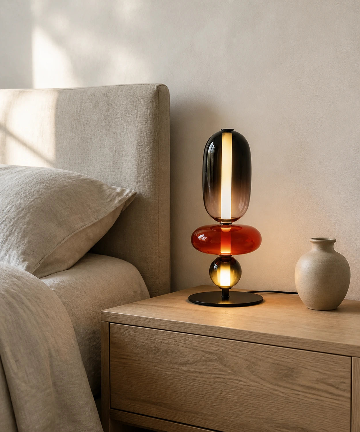 Lampe à poser à quatre boules de verre teinté sur une table de chevet Image