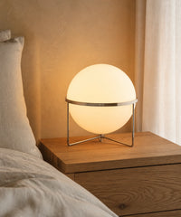 Lampe à poser à boule opaline sur une table de chevet