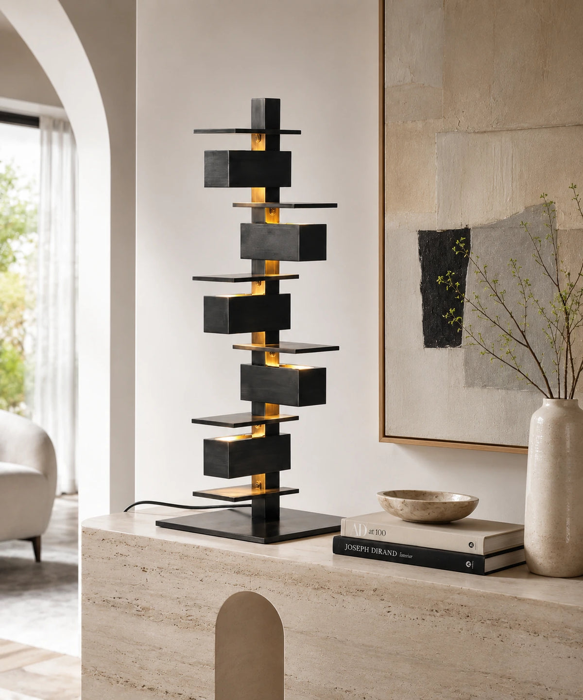 Lampe à poser design noire de 70 cm sur une console en travertin, dans un salon clair